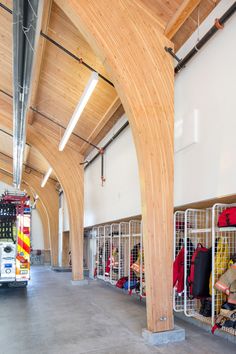 a fire truck is parked in a large room with wooden beams on the ceiling and walls