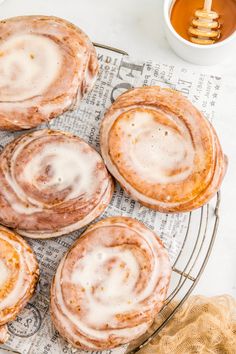 cinnamon rolls on a wire rack with honey in the background