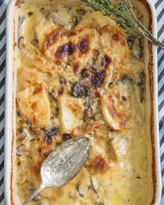 a casserole dish with meat and cheese in it on a striped table cloth