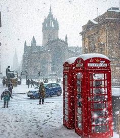 a red phone booth sitting in the middle of a snow covered street