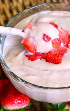 a glass bowl filled with yogurt and strawberries