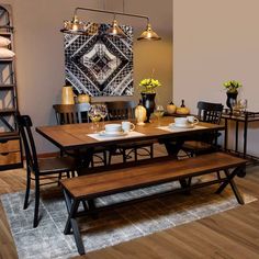 a dining room table with two benches in front of it and an area rug on the floor