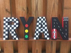 the letters are made out of wood and have cars on them, along with checkered flags