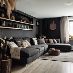 a living room filled with furniture and lots of shelves on the wall above it's windows