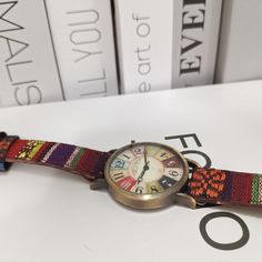 a watch sitting on top of a table next to books