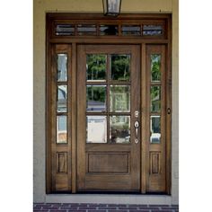 a wooden door with glass and brick walkway