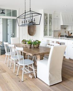 a dining room table with chairs and a basket hanging from the ceiling in front of it