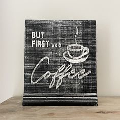 a black and white sign that says but first, coffee is on it's side