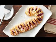 a white plate topped with pastries on top of a wooden table next to a knife and fork