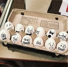 an egg carton filled with lots of eggs covered in face drawn on the inside