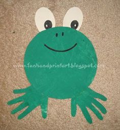 a green frog made out of foam on the ground with eyes and hands painted onto it