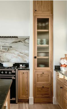 a kitchen with wooden cabinets and marble counter tops, along with an area rug on the floor