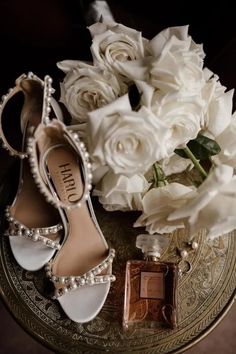 wedding shoes, perfume and flowers on a table