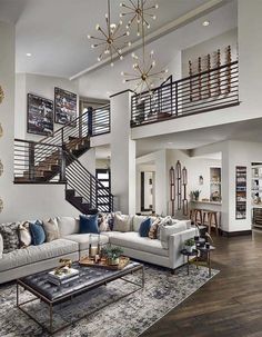 a living room filled with lots of furniture and a stair case in the middle of it