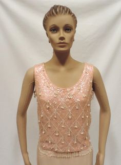 Beaded Blouse 50s Sequin Wiggle Top Pink Wool Sleeveless Shell Christmas Holiday Party Separates Vintage Size S 1950s Beautiful and shiny pink sleeveless shell perfect for holiday, party or casual wear Blouse is fully lined, has back metal zipper closure, bead dangles and is generously covered in iridescent sequins. Size S fabric has some stretch approximate measurements Bust underarm to underarm- 36 inches Waist- 34 inches Shoulder to shoulder-14.5 inches Length shoulder to hem-20 inches Has ma Festive Sleeveless Holiday Top, Elegant Pink Evening Tank Top, Elegant Pink Tank Top For Evening, Beaded Sleeveless Top For Party, Spring Beaded Tank Top For Party, Festive Sleeveless Beaded Top, Festive Beaded Sleeveless Top, Spring Party Beaded Tank Top, Elegant Sleeveless Tank Top For Festive Occasions