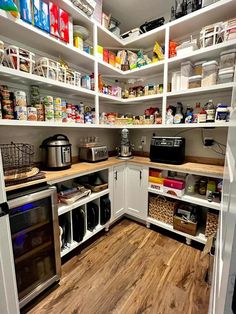 a kitchen with white cabinets and wooden floors