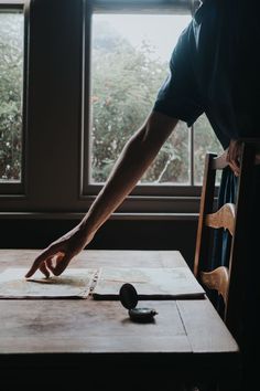 A woman points at an atlas open on a table next to a compass, in front of a window Aesthetic Journals, Stationery Design Inspiration, Notebooks Aesthetic, Photography Storytelling, Journals And Notebooks, Writing Motivation, Storytelling Photography, Forgotten Realms, Slow Living