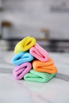 a stack of multicolored doughnuts sitting on top of a white counter