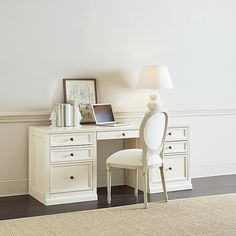 a white desk with a laptop on top of it and a lamp next to it