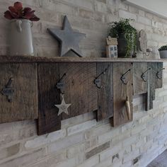 a brick wall with several wooden stars on the top and two potted plants on each shelf