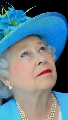 an older woman wearing a blue hat and pearls