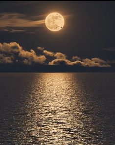 the full moon shines brightly in the sky above the water's surface at night