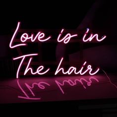 a neon sign that says love is in the hair