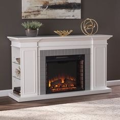 a white fireplace with an electric fire in the middle and a painting on the wall behind it