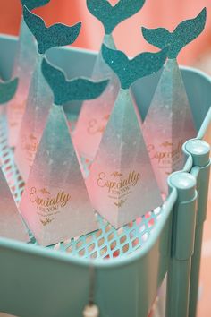 some pink and blue paper bags with little mermaids on them sitting in a basket