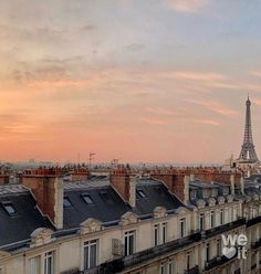 the eiffel tower is in the distance as seen from an apartment building at sunset