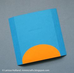 an orange and blue book sitting on top of a gray table next to a white wall