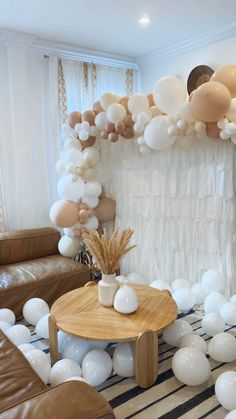 a living room decorated with balloons and white balls on the floor, along with a coffee table