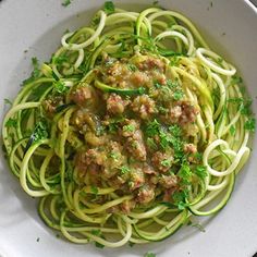 a white bowl filled with zucchini and meat sauce