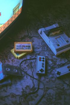 several nintendo wii game controllers sitting on the floor next to an old fashioned video game console