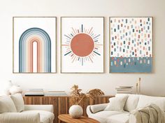 three paintings hang on the wall in a living room