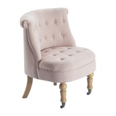 an upholstered pink chair with wooden legs and buttons on the armrests