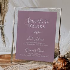 a sign that says signature drinks on it next to a vase with feathers in it