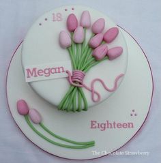 a birthday cake decorated with pink flowers and a name tag for eighteen year old girl