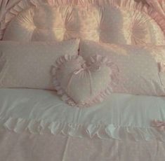 there is a bed with pink and white pillows on it