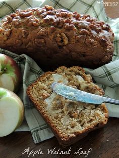 a loaf of apple walnut bread next to sliced apples and a knife on a napkin