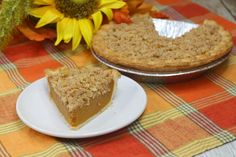 a slice of pie on a plate next to a sunflower