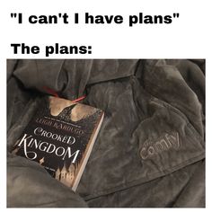 an open book laying on top of a bed next to a jacket with the words, i can't have plans the plans