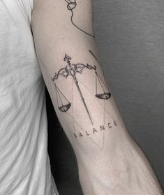 a man with a tattoo on his arm that says balance and an arrow in the middle