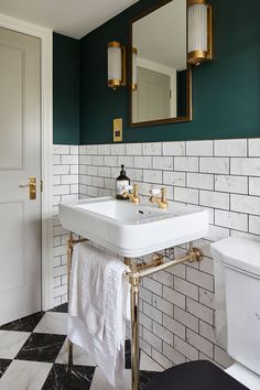 a white sink sitting under a bathroom mirror next to a black and white checkered floor