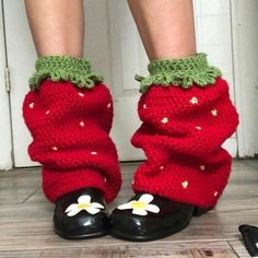 the legs and ankles of a woman wearing red knitted socks with white flowers on them