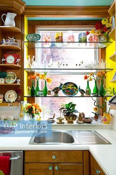 a kitchen filled with lots of clutter next to a window