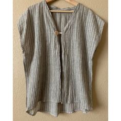 a gray and white striped top hanging on a wall