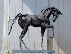 a sculpture of a horse is shown in front of a building