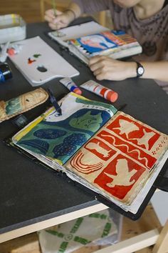 a person sitting at a table with some art supplies