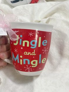 a person holding a coffee cup with a pink bow on it's handle and label that says single and mingle